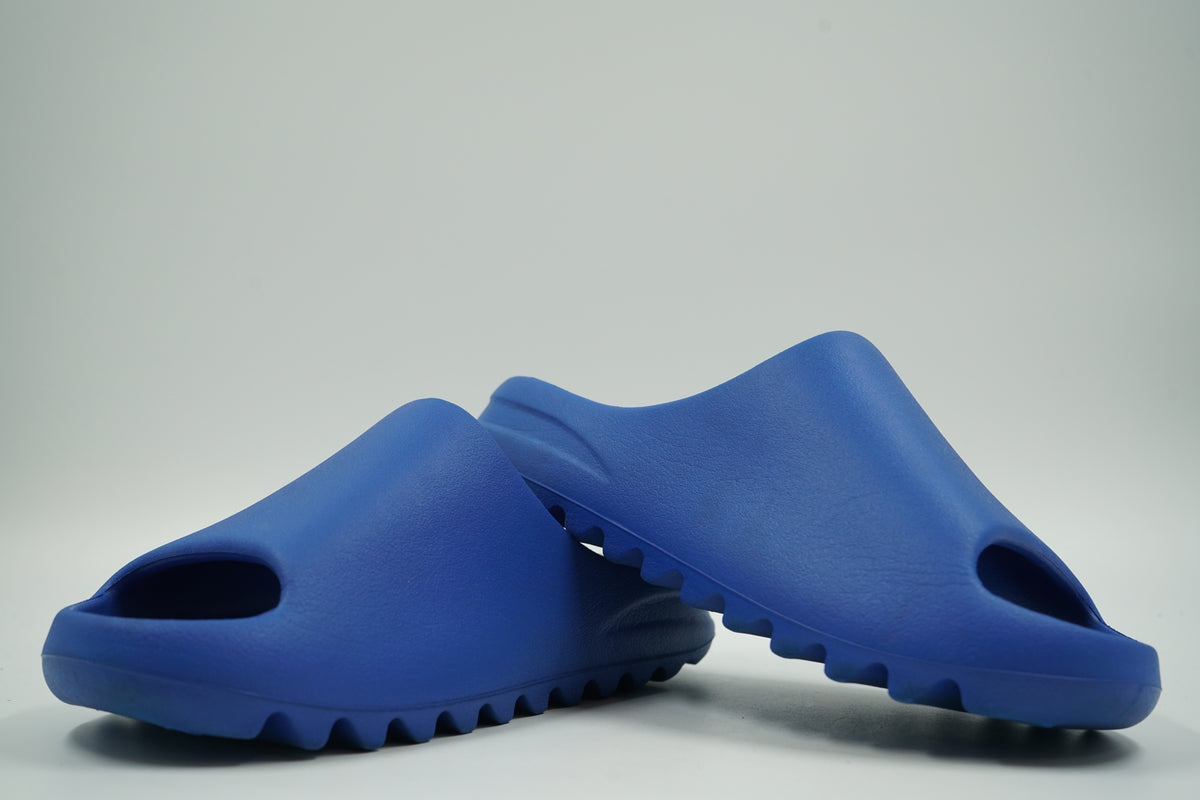 Pair of pre-owned adidas Yeezy Slides in Azure blue foam, stacked view of inner sides