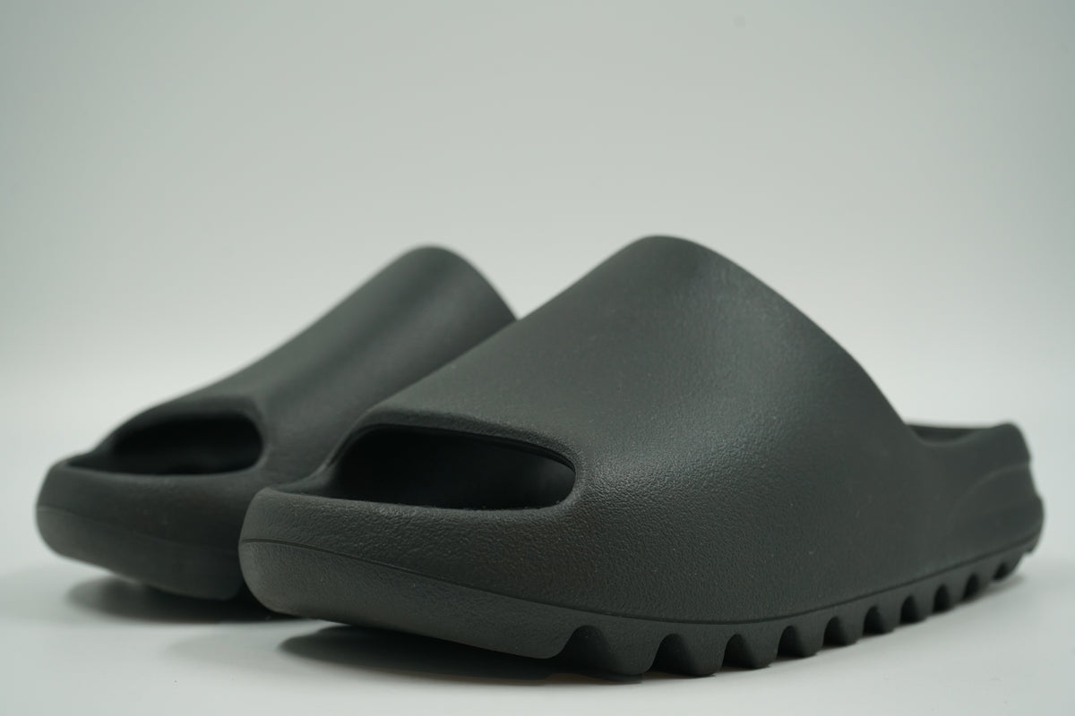 Pair of pre-owned adidas Yeezy Slides in Dark Onyx moulded foam, front angle view
