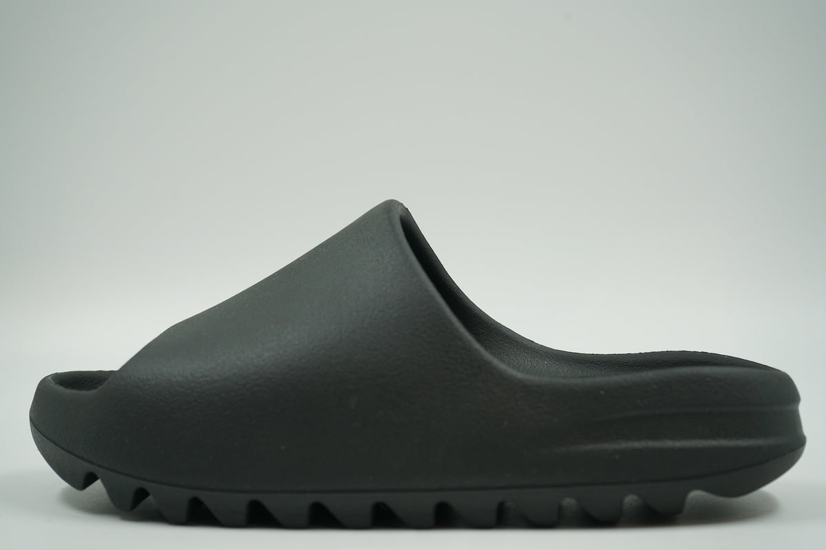 Pre-owned adidas Yeezy Slide in Dark Onyx moulded foam with ridged sole, side view