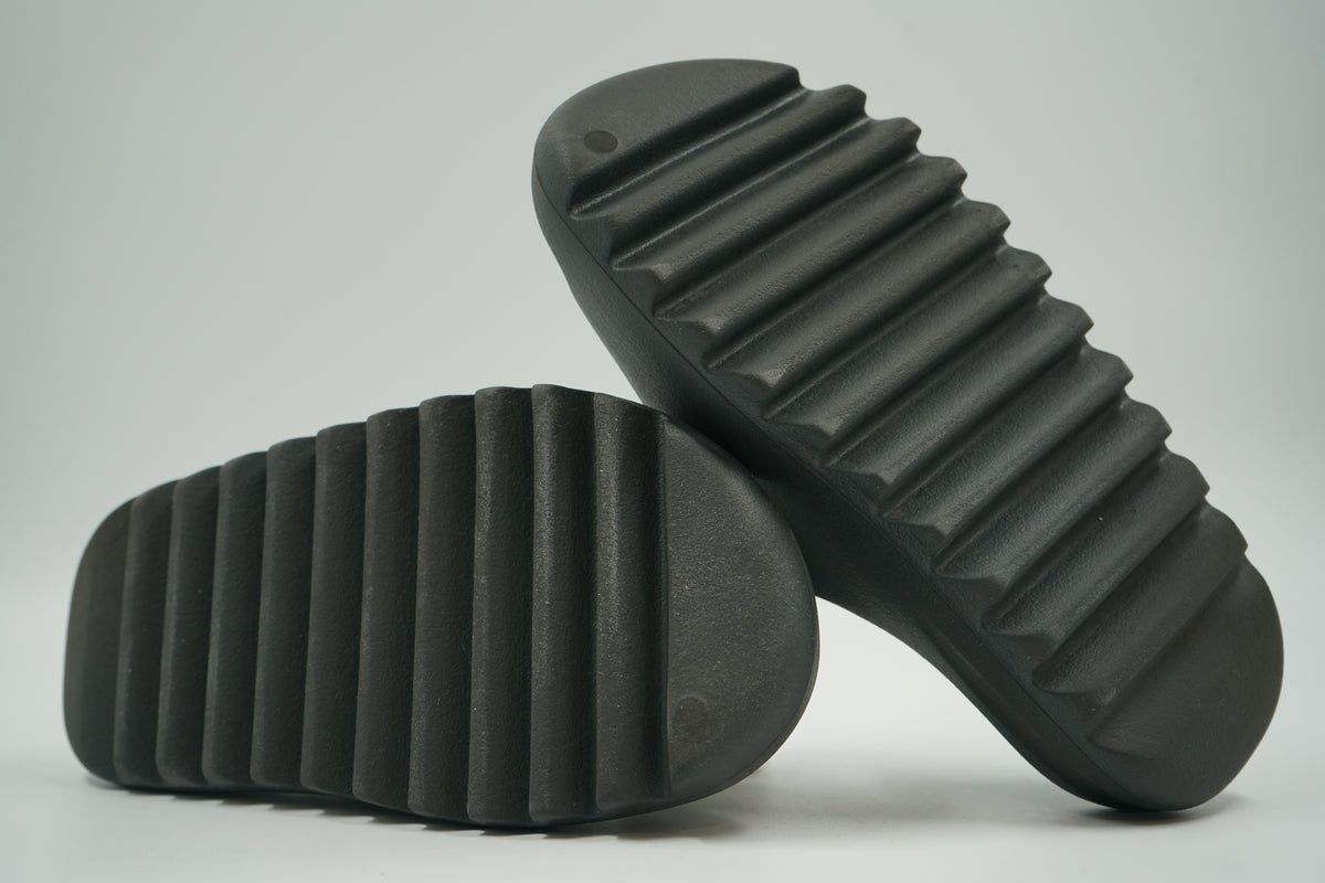 Pre-owned adidas Yeezy Slide in Dark Onyx, outsole view with deep ridged foam tread