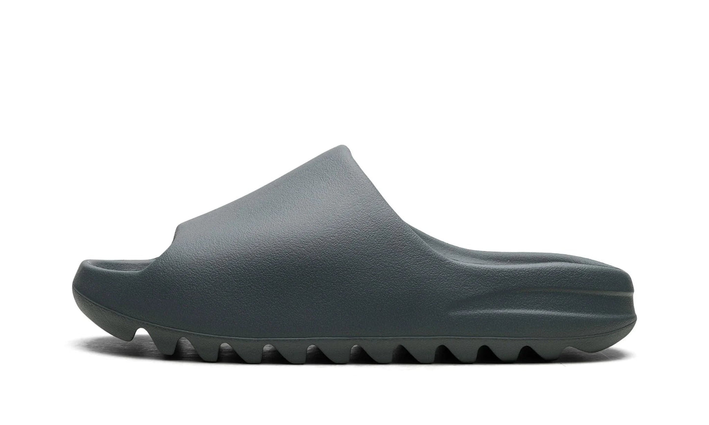 Adidas Yeezy Slide 'Slate Marine' featuring a muted grey-blue EVA foam construction and serrated sole. Minimalist slip-on sandal available at our Malmö store.