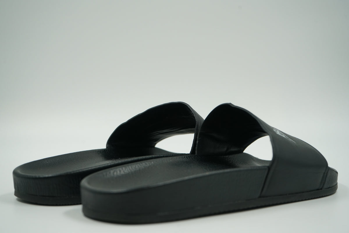 Pair of pre-owned Balenciaga pool slides in black, back view of heels and grained footbed