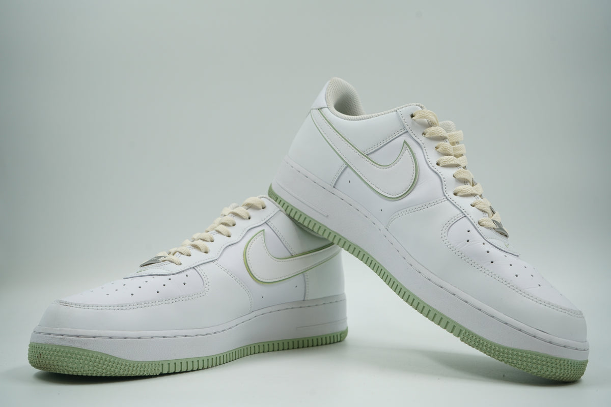 Pair of pre-owned Nike Air Force 1 ‘07 in white and honeydew, stacked view showing the inner sides