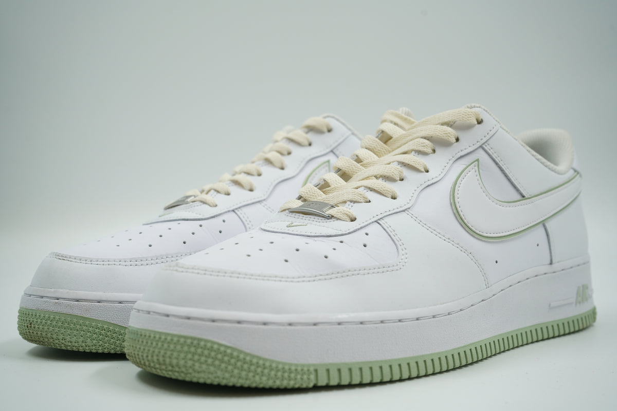 Pair of pre-owned Nike Air Force 1 ‘07 Low in white and honeydew green, front angle with silver dubrae