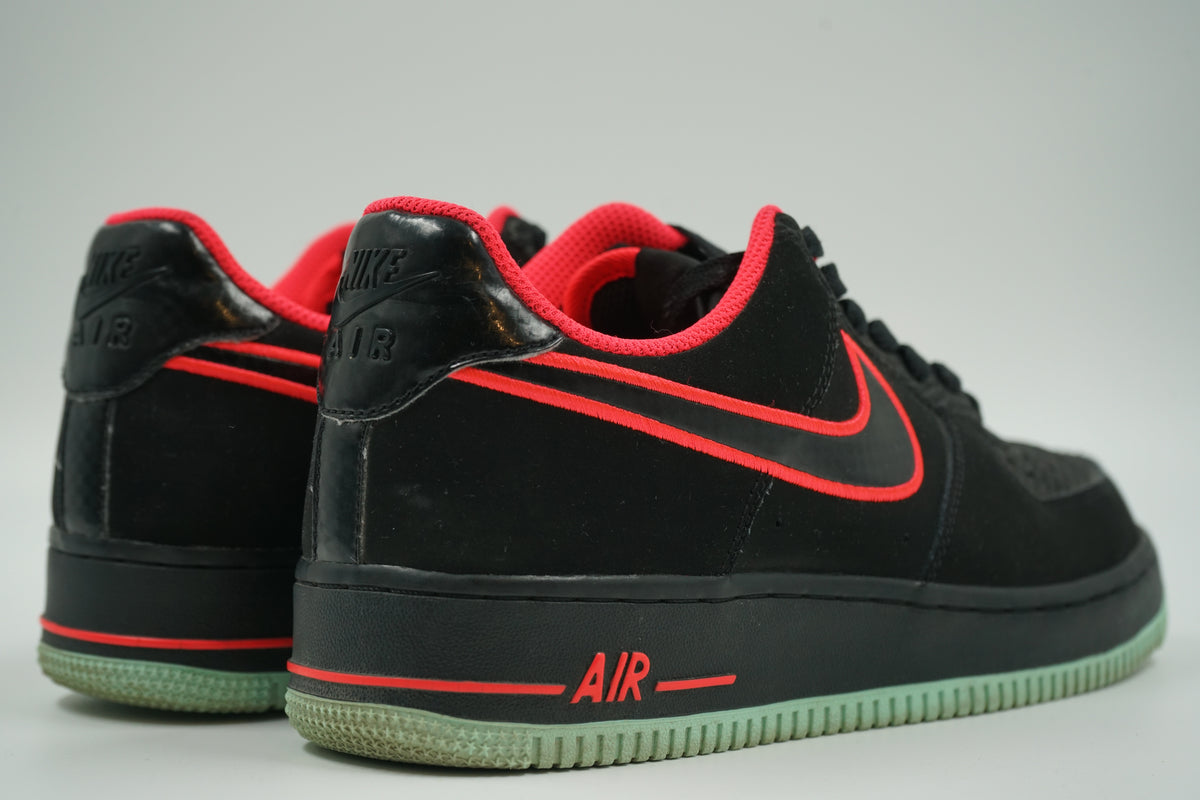 Pair of pre-owned Nike Air Force 1 Low Yeezy in black, back view with glossy embossed Nike Air heel tab
