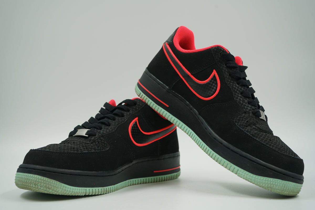 Pair of pre-owned Nike Air Force 1 Low Yeezy in black, stacked view of inner sides with Solar Red outlines