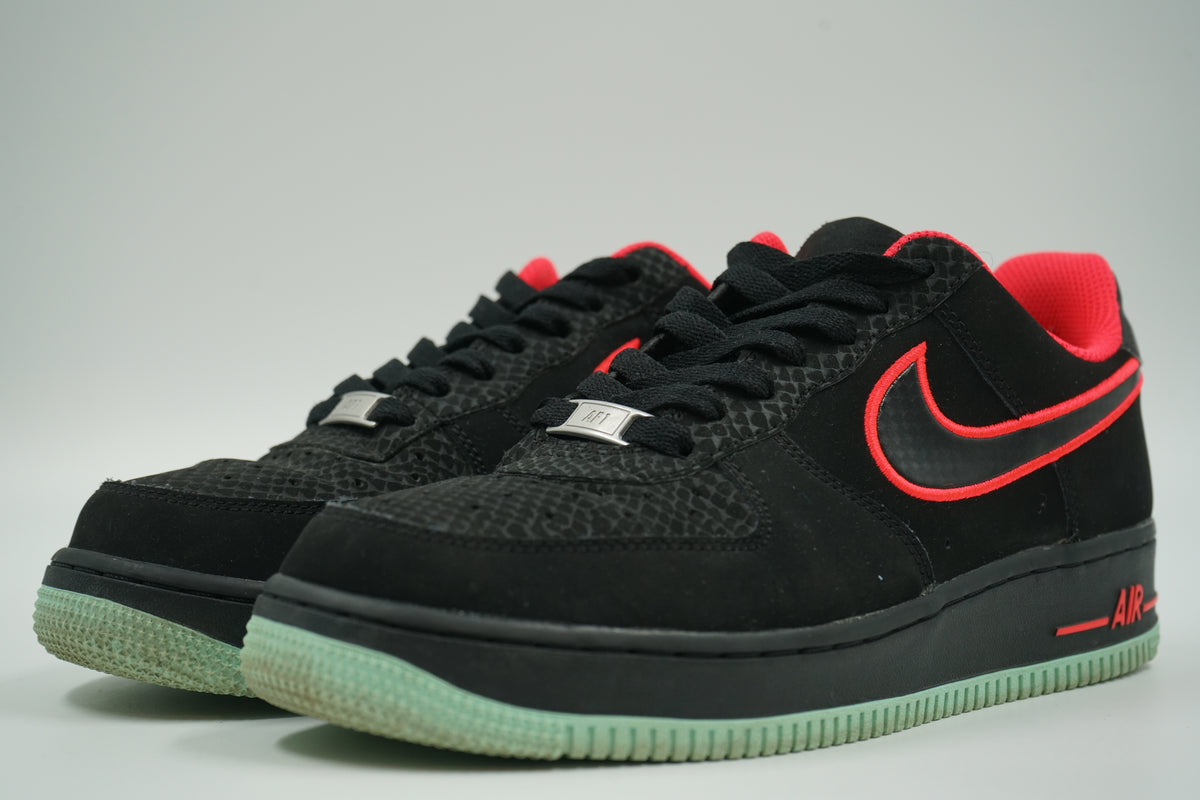 Pair of pre-owned Nike Air Force 1 Low Yeezy in black with Solar Red details and glow sole, front angle view