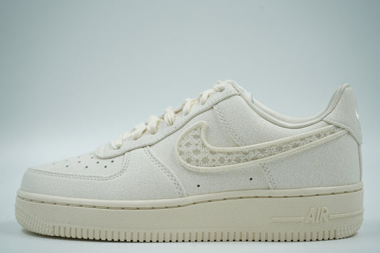 Pre-owned Nike Air Force 1 in sail textile with woven patterned Swoosh and cream sole, side view