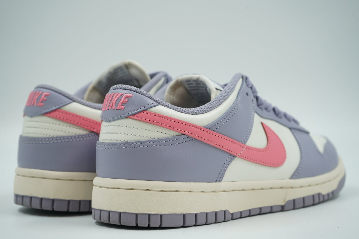 Pair of pre-owned women’s Nike Dunk Low Indigo Haze, back view with pink embroidered Nike heel logo