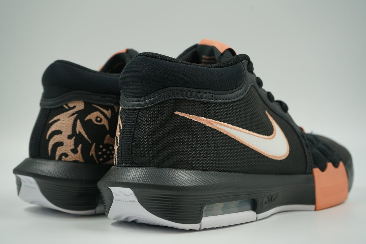 Pair of pre-owned Nike LeBron Witness 8 in black and peach, back view with embroidered lion heel graphic
