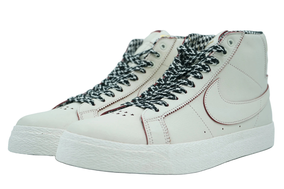 Pair of Nike SB Blazer Mid in sail leather with houndstooth laces, star toe perforations and burgundy stitching, front view