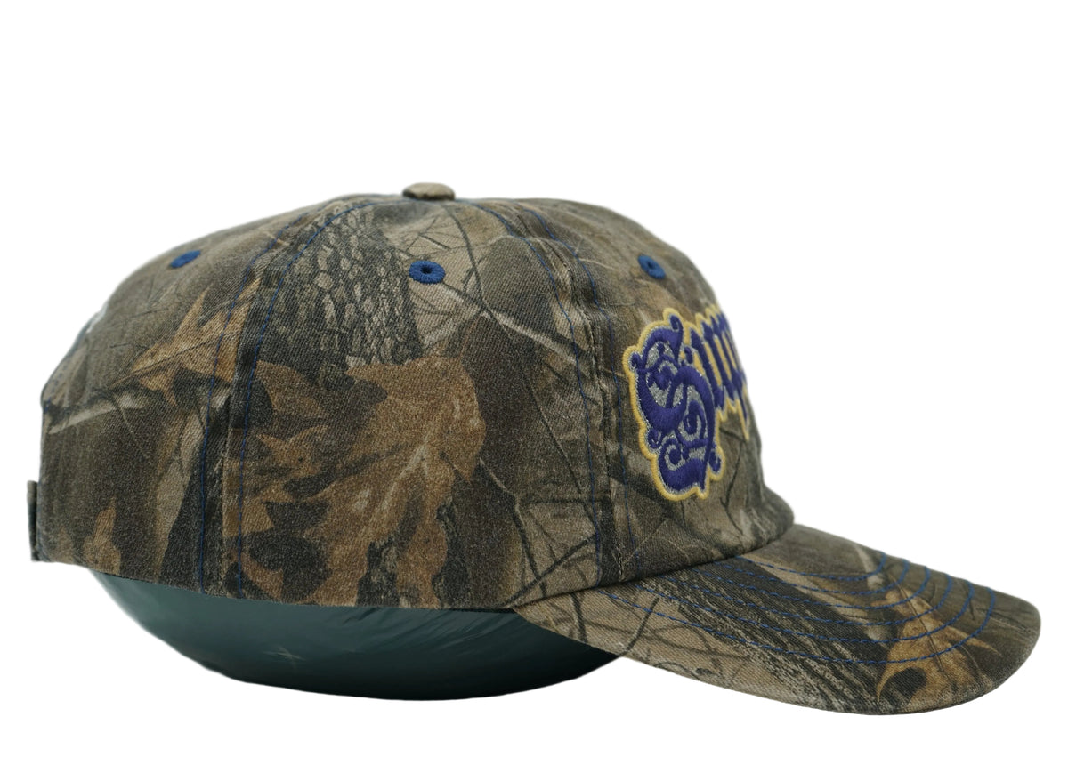Supreme Bottle Opener 6-Panel cap in brown tree camo with purple gothic logo and blue stitching, side profile view