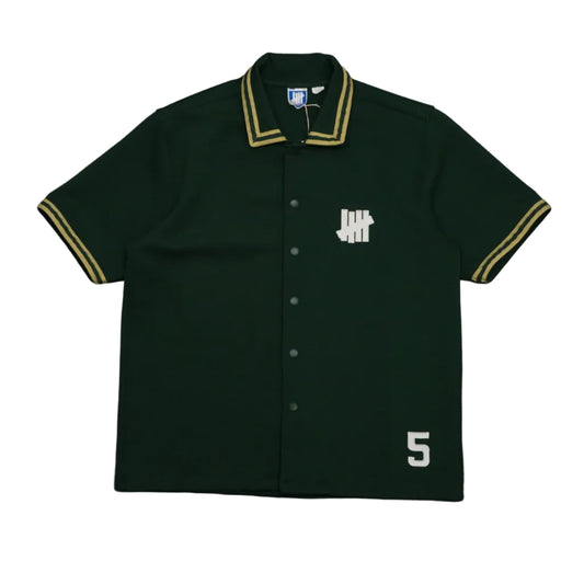 Pre-owned Undefeated snap button shirt in dark green with gold striped trim and 5 Strike logo patch, front view