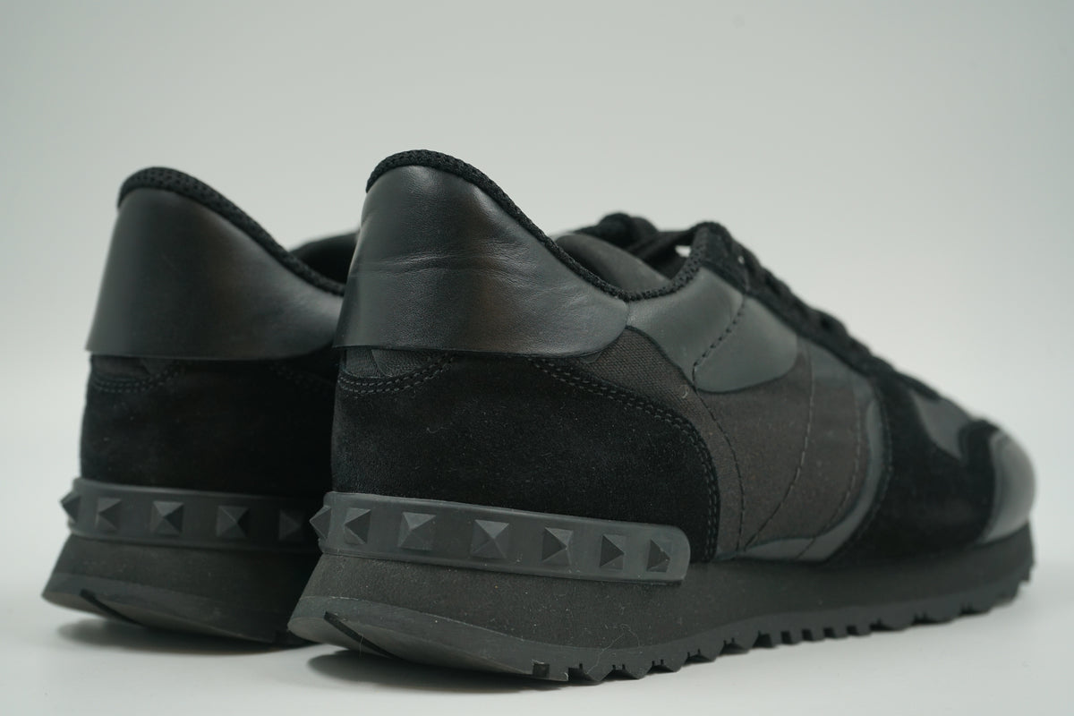 Pair of pre-owned Valentino Garavani Rockrunner in black, back view with tonal black Rockstud heel counters