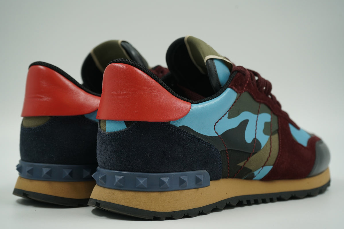 Pair of pre-owned Valentino Garavani Rockrunner in blue camo, back view with red heel tabs and navy Rockstuds