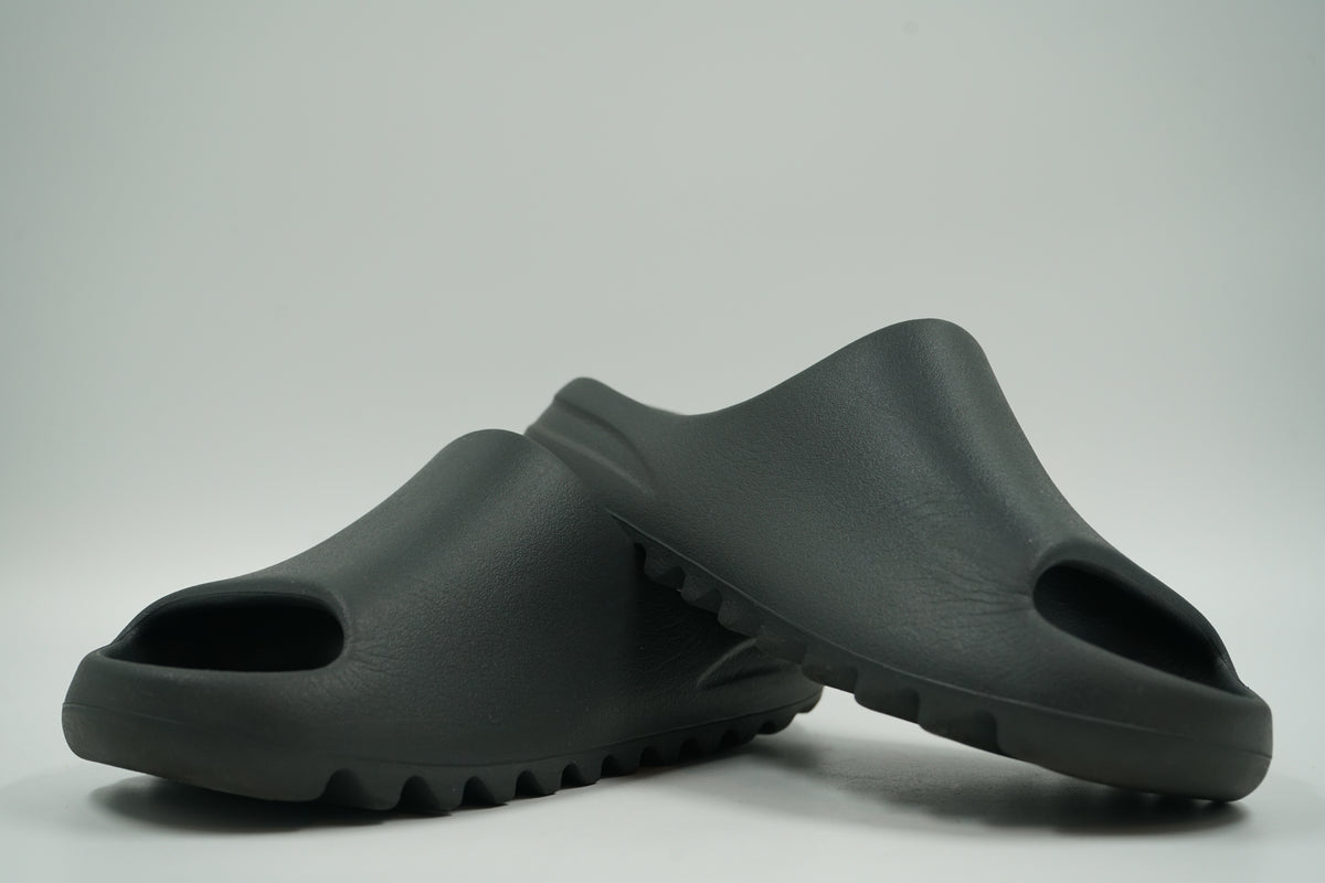 Pair of pre-owned adidas Yeezy Slides Onyx, second angle of the black foam straps